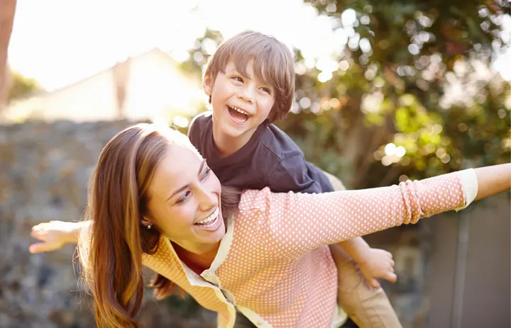 Smiling child on an adult's back