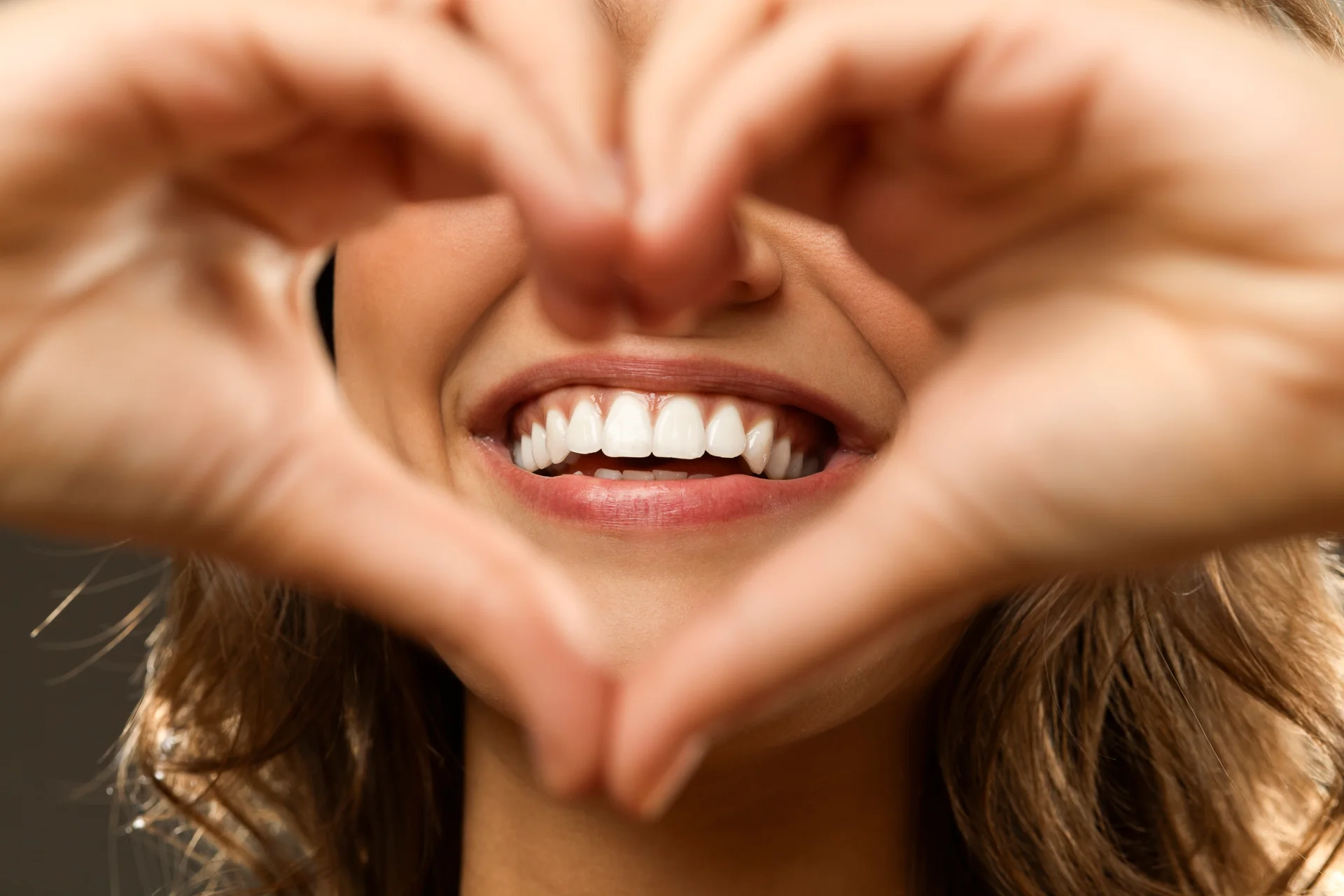 Smiling woman making a heart shape with her hands