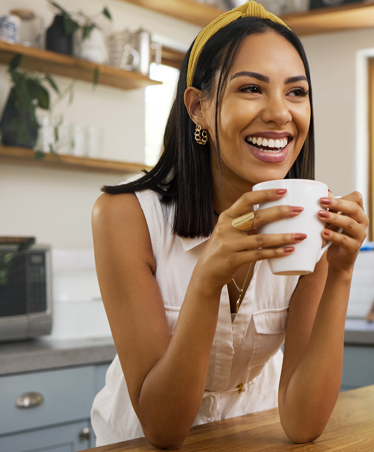 A smiling woman holding a mug