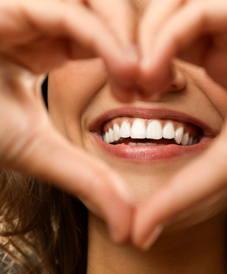 A close-up smile framed by hands