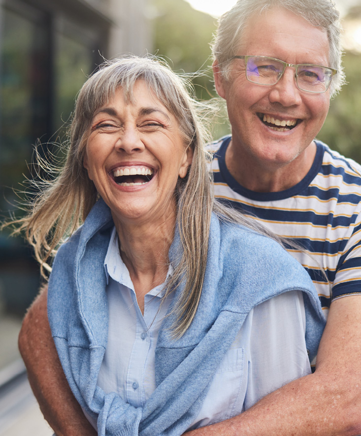 An older couple smiling outside