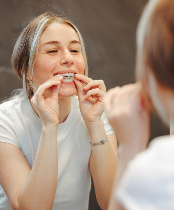 A patient looking at their teeth in the mirror